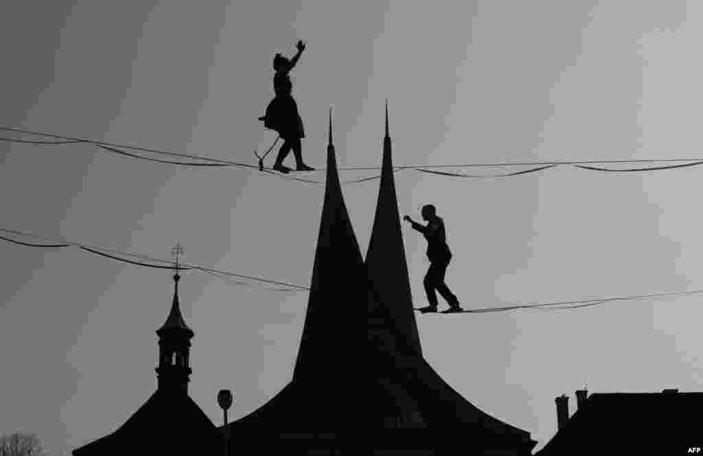 Tightrope artists balance on a rope in front of the Emmaus Monastery in Prague, Czech Republic.