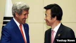 25일 라오스 비엔티안에서 열린 미-한 외교장관 회담에서 존 케리 미 국무부 장관(왼쪽)이 윤병세 한국 외교장관과 악수하고 있다.