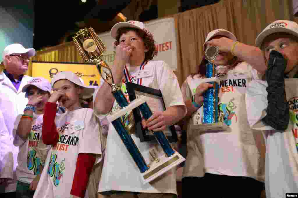 Connor Slocombe, from Eagle River, Alaska, holds his trophy with other contestants after winning Odor-Eater&#39;s Rotten Sneaker Contest at Ripley&#39;s Believe It or Not! in Times Square in New York.
