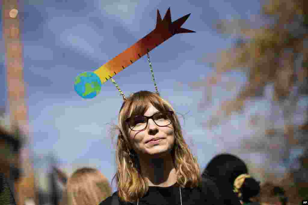 A woman marches with other thousands during a climate protest in Brussels, Friday, Sept. 20, 2019. In Canberra and Kabul, Cape Town and Berlin, and across the globe, hundreds of thousands of people took the streets Friday to demand that leaders tackle climate change in the run-up to a U.N. summit. (AP Photo/Francisco Seco)