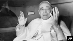FILE - Pope Pius XII smiles as he waves with both arms, sitting in his car, in response to the cheers from a crowd gathered outside the papal summer residence, Nov. 29, 1955, just as the Pontiff leaves for the Vatican, about 18 miles away.