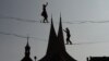 Tightrope artists balance on a rope in front of the Emmaus Monastery in Prague, Czech Republic.