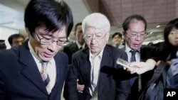 One of three Japanese, center, who had been detained by Chinese military and released today, is escorted by company's officials upon arrival at Pudong International Airport in Shanghai, 30 Sep 2010