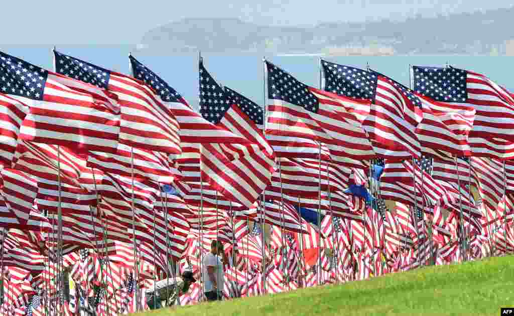 People visit the Pepperdine Wave of Flags display at Pepperdine University in Malibu, California, Sept. 10, 2019, commemorating those who died in the Sept. 11, 2001 terrorist attacks with 2,977 flags.