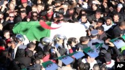 The coffin of Hocine Ait Ahmed, who spent nearly a quarter-century in exile in Europe, is carried during a burial ceremony in his native village, Ath Ahmedh, Algeria, Jan.1, 2016.
