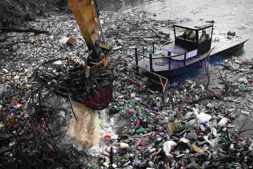 A crane clears tons of garbage stuck at the foot of the hydro power plant at the Potpecko accumulation lake near Priboj, in southwest Serbia.