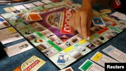 FILE - Players participate in a world record attempt by Monopoly enthusiasts across the world to set a Guinness world record for the largest simultaneous game of Monopoly, at a hotel in Madrid, Aug. 27, 2008.