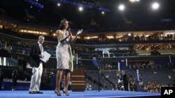 Ibu negara Michelle Obama tampil di panggung di Time Warner Cable Arena di Charlotte, North Carolina (3/9), sementara panitia konvensi Partai Demokrat melakukan tes kamera sebagai persiapan acara konvensi hari Selasa.