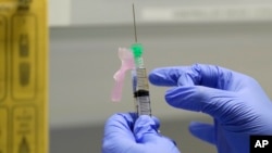 資料照片：在倫敦一家診所，一位臨床研究護士準備註射新冠病毒疫苗。 (2020年8月5日)