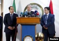 A member of the Presidential Council of Government of National Accord, Ahmed Maiteeq (L) and Italian Foreign Minister Paolo Gentiloni (C) hold a joint news conference in Tripoli, Libya, April 12, 2016.