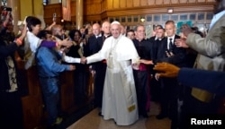 Pope Francis greets parishioners, immigrants and clients of Catholic Charities, as he arrives at St. Patrick's Church, in Washington, Sept. 24, 2015.