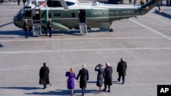 প্রেসিডেন্ট ডনাল্ড ট্রাম্প এবং ফার্স্ট লেডি মেলানিয়া ট্রাম্প (ডানে) প্রাক্তন প্রেসিডেন্ট জো বাইডেন এবং জিল বাইডেনকে হেঁটে হেলিকপ্টার পর্যন্ত পৌঁছে দিচ্ছেন। ফটোঃ ২০ জানুয়ারি, ২০২৫।