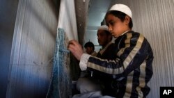 Anak-anak pengungsi Afghanistan menenun karpet di sebuah pabrik karpet di Pakistan (foto: ilustrasi).