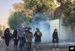Polisi anti huru-hara Iran menembakkan gas air mata ke arah pengunjuk rasa yang memrotes kematian Mahsa Amini di depan Universitas Teheran (foto: dok).