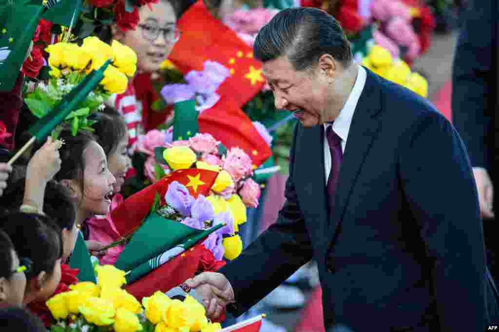 China&#39;s President Xi Jinping, right, shakes hands with a girl as she and other children welcome Xi upon his arrival at Macau&#39;s international airport in Macau.