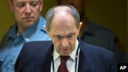 FILE - In this Wednesday April 8, 2015 file photo, Zdravko Tolimir, a Bosnian Serb general convicted of genocide in the 1995 Srebrenica massacre, is escorted by U.N. security guards as he arrives in the courtroom of the the Yugoslav war crimes tribunal wh