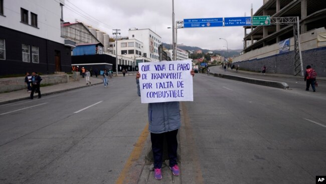 Un taxista sostiene un cartel con un mensaje que dice: "Viva el paro del transporte por falta de combustible", durante una protesta en La Paz, Bolivia, el miércoles 23 de octubre de 2024.