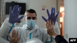 Le physiothérapeute espagnol Vicente Barrios s'entraîne avec le premier résident infecté par le coronavirus et guéri, dans une maison de retraite pour personnes âgées à Madrid le 24 avril 2020. (Photo de OSCAR DEL POZO / AFP)