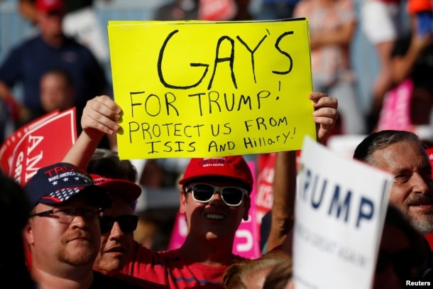 A person holds up a "Gays for Trump" sign as then-Republican presidential nominee Donald Trump holds a campaign event in Orlando, Fla., Nov. 2, 2016.