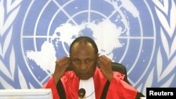 FILE - Judge Lloyd Williams of the International Criminal Tribunal for Rwanda adjusts his headphones, April 2, 2002, during one of the court's first sessions.