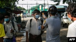 အဝင်အထွက်ပိတ်ဆို့ထားသည့် ရန်ကုန်မြို့ လမ်းသွယ်တခုတွင် ကိုယ်အပူချိန် တိုင်းတာပေးနေသည့် လုပ်အားပေးများ။ (စက်တင်ဘာလ ၁၁၊ ၂၀၂၀)