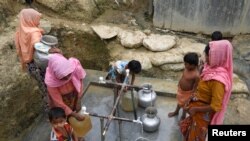 FILE - Rohingya refugees collect drinking water at the Shalbagan refugee camp in Teknaf, Bangladesh, March 5, 2019.