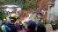 In this handout photo released by the Caldas Department Press Office, rescue workers attend to the wreckage of a house destroyed by a landslide in Marquetalia, Colombia, Oct. 11, 2018.