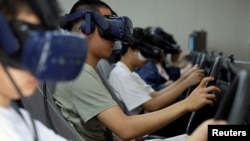 Students wearing virtual reality (VR) headsets practise on car driving simulators at Eastern Pioneer Driving School in Beijing, China July 23, 2024.