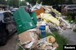 A man disposes of drywall while salvaging through belongings from his family home in the aftermath of Tropical Storm Harvey in Houston, Sept. 2, 2017.