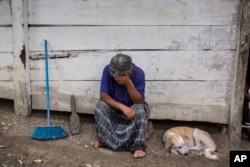 Elvira Choc, 59, Jakelin Caal Maquin's grandmother, rests her head on her hand in front of her house in Raxruha, Guatemala, Dec. 15, 2018.