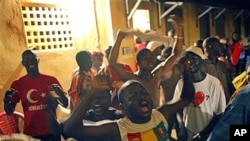 Supporters of Guinean presidential candidate Alpha Conde celebrate at his headquarters after it was announced by the National Independent Electoral Commission that the preliminary results showed he had won Guinea's tense presidential election, 15 Nov 2010