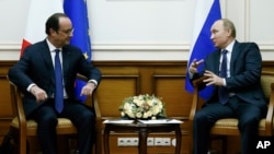 Russian President Vladimir Putin, right, and French President Francois Hollande speak during their meeting at Moscow's Vnukovo airport, Saturday, Dec. 6, 2014.