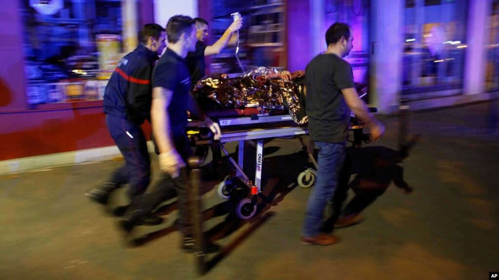 FILE - In this November 2015, photo, a person is evacuated after a shooting, outside the Bataclan theater in Paris. 