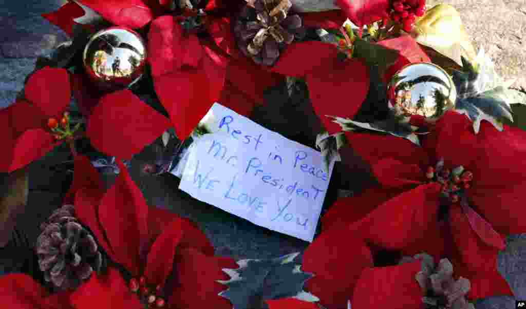 Венок с посланием Джорджу Бушу-старшему лежит на временном мемориале напротив Уолкер-Пойнта, летнего дома Буша в Кеннебанкпорте, штат Мэн