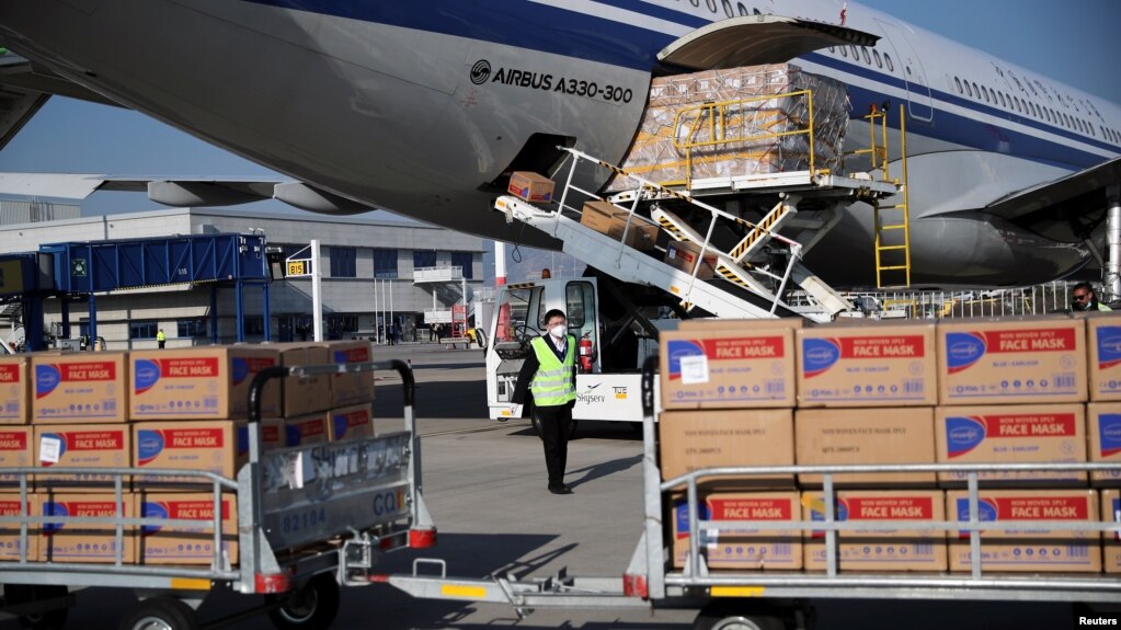 希腊雅典国际机场的工人从国航飞机上卸下装有中国政府捐赠的抗疫医疗用品。（2020年3月21日）