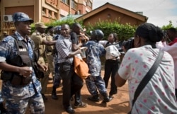 FILE - Waandishi wa Habari na wanachama wa mtandao wa Haki za Binadamu Uganda wakipambana na polisi wakati wa maandamano Kampala, Uganda, May 28, 2013.