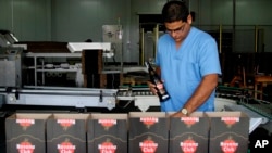 FILE - A worker checks the production of Havana Club rum at the company's factory in Havana, Cuba. 