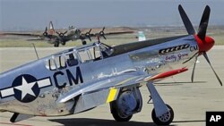 A North American P-51 Mustang is seen in the foreground as a Boeing B-17 Flying Fortress 'Nine O Nine' World War II Heavy Bomber taxis behind it as part of the Wings of Freedom tour to honor World War II veterans, in Sunnyvale, California, December 2011. 