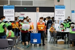 香港選舉人員在為選舉委員會舉行投票後在點票中心交付投票箱。（2021年9月19日）