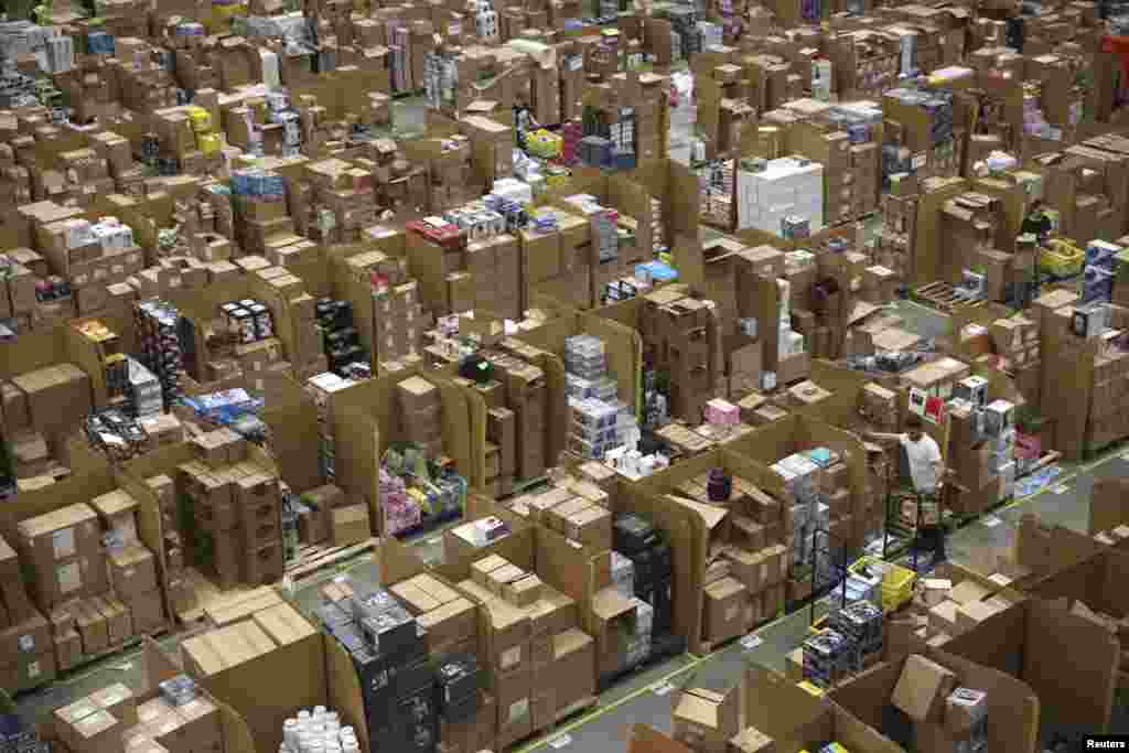 Workers collect customer orders during Black Friday deals week at an Amazon fulfilment center in Hemel Hempstead, Britain.