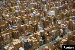 FILE - Workers collect customer orders at an Amazon fulfilment center in Hemel Hempstead, Britain, Nov. 25, 2015.