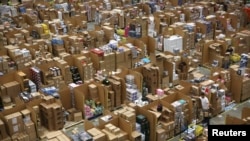 Workers collect customer orders during Black Friday deals week at an Amazon fulfilment centre in Hemel Hempstead, Britain November 25, 2015. 