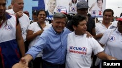 Peruvian presidential candidate Cesar Acuna (C) greets supporters during a rally at a market in the Brena district of Lima, Jan. 25, 2016.