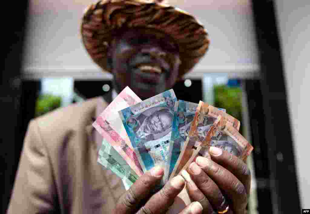 July 19: A man from South Sudan displays new currency notes outside the Central Bank of South Sudan in Juba. South Sudan started rolling out its new currency on Monday: the South Sudan Pound. REUTERS/Benedicte Desrus
