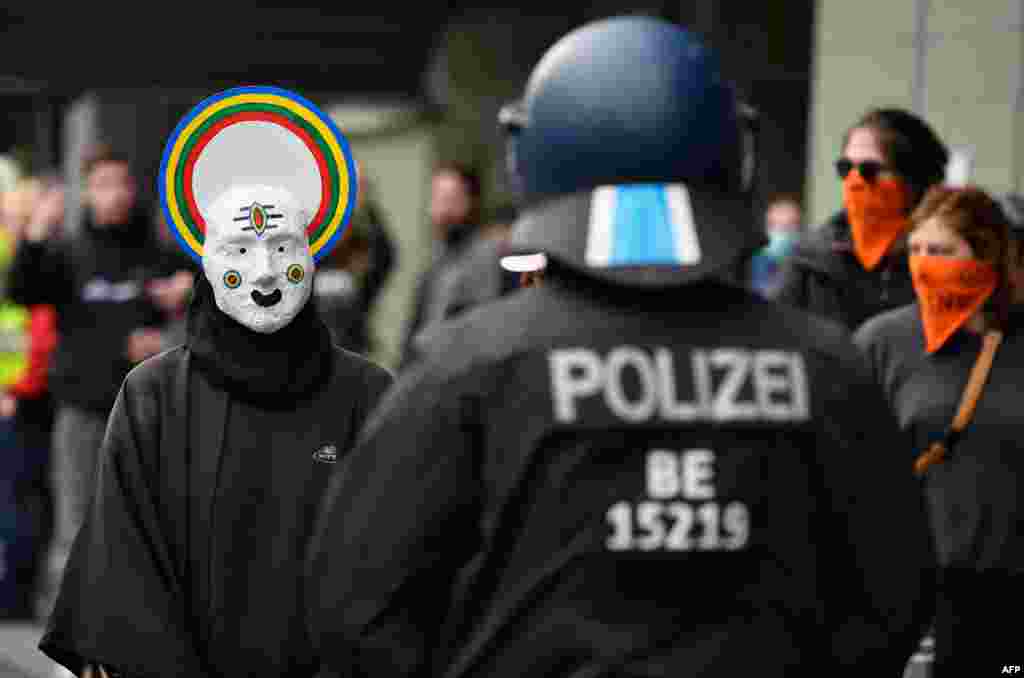 A protester wearing a mask is seen with police during May Day protests amid the COVID-19 outbreak, in Berlin&#39;s Kreuzberg district, Germany.