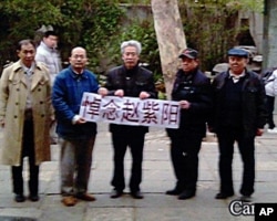 山東大學退休教授孫文廣(中)和朋友在公園拉開橫幅悼念趙紫陽