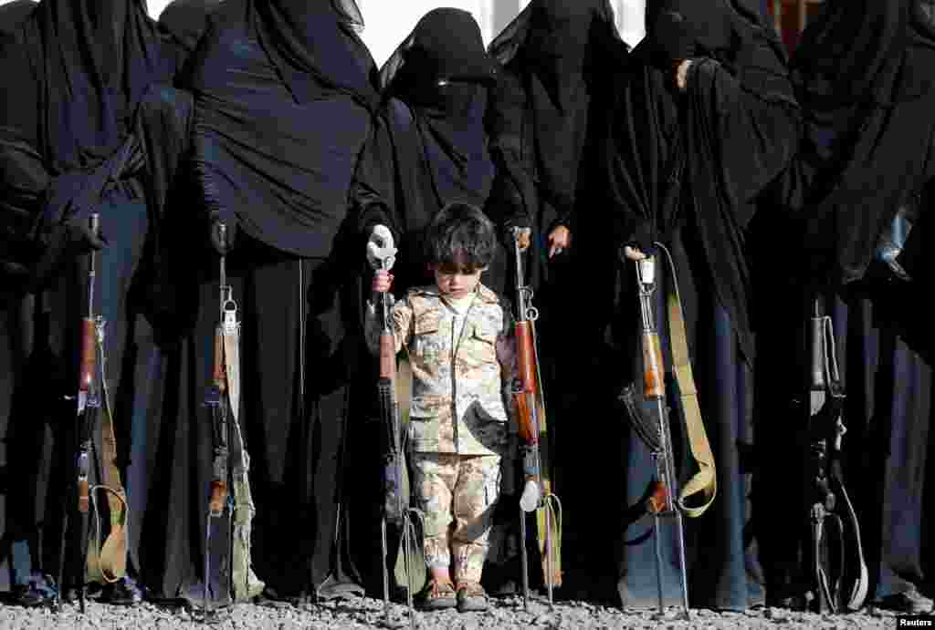 A boy stands with women loyal to the Houthi movement during a gathering held to show their support to the movement in Sanaa, Yemen.