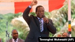 In this image taken on Wednesday Feb, 10, 2016, Zimbabwean Deputy President Emmerson Mnangagwa greets party supporters at the ZANU-PF headquarters in Harare. (AP Photo/Tsvangirayi Mukwazhi)