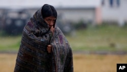 A Quiche indigenous woman walks in the rain in Santa Maria Ixtahuacan, Guatemala, Sunday Sept. 5, 2010. Torrential rains from a tropical depression caused landslides that have killed at least 38 people in Guatemala. (AP Photo/Moises Castillo)