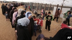 지난 1월 유엔총회 모겐스 뤼케토프트 의장이 요르단 마프라프 난민캠프를 방문한 가운데, 시리아 여성들이 유엔 지급 겨울 구호품을 받기 위해 줄을 서 있다.